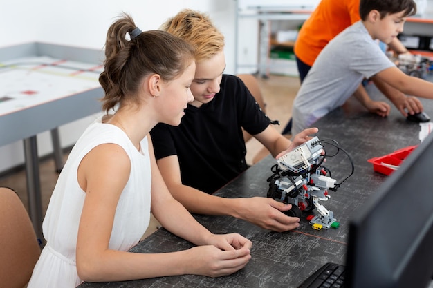 Los escolares programan un robot en el aula.