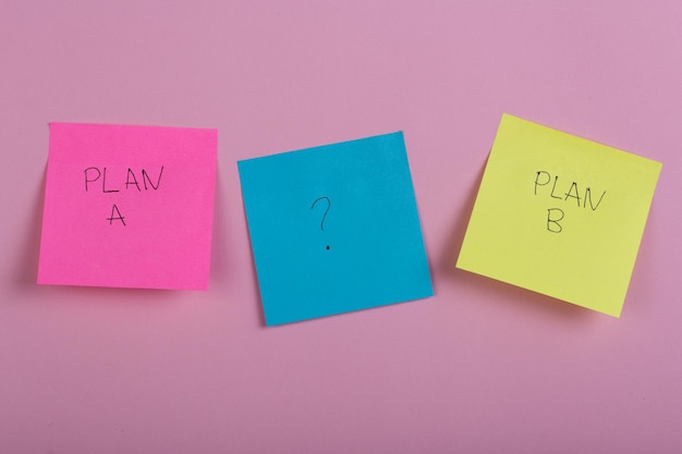 Escolha de negócios - Planeje um ou plano b em adesivos coloridos de escritório em fundo rosa