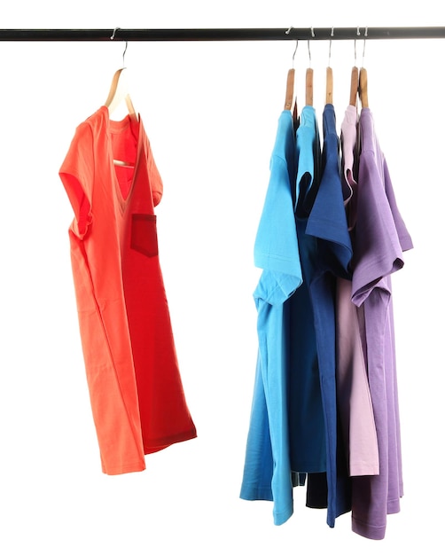 Escolha de roupas de cores diferentes em cabides de madeira isolados em branco