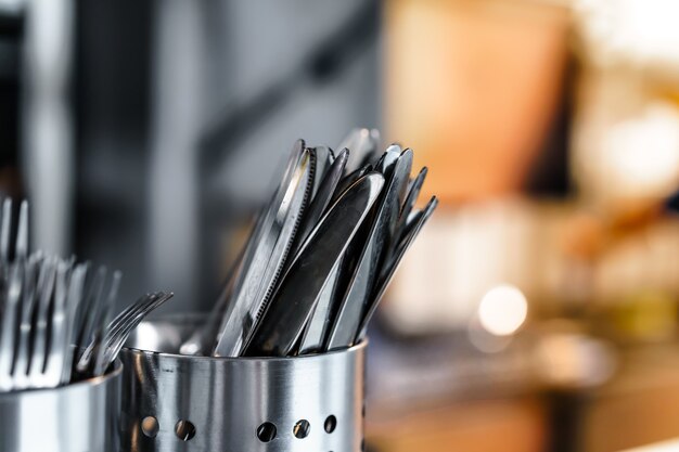 Escorredores de talheres de metal em cozinha profissional de restaurante de perto