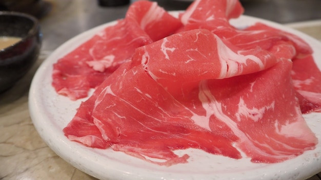 Escorrega de carne crua japonesa para shabu shabu em restaurante japonês.