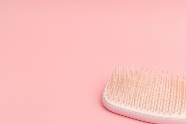 Escova de cabelo de plástico com fundo rosa