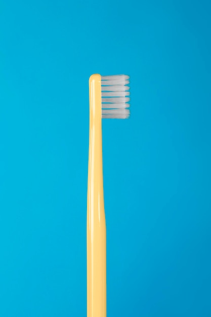 Escova de dentes amarela sobre fundo azul
