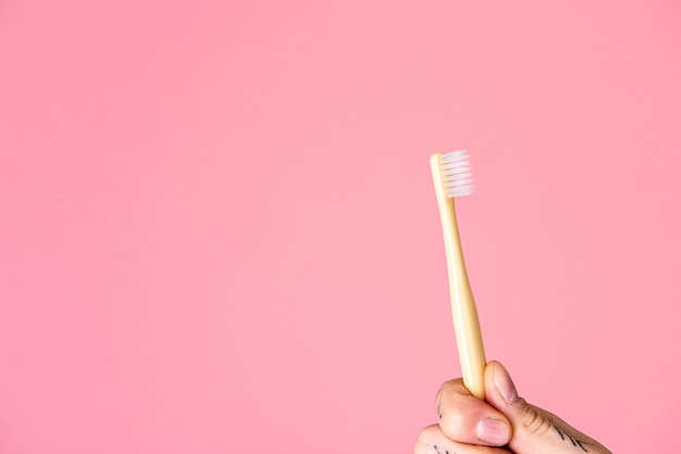 Escova de dentes contra um fundo rosa