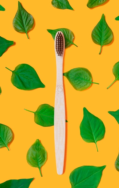 Foto escova de dentes de bambu com folhas verdes. conceito de desperdício zero