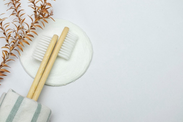 Escova de dentes de bambu ecológica com toalha de banheiro e fita vermelha sobre fundo branco