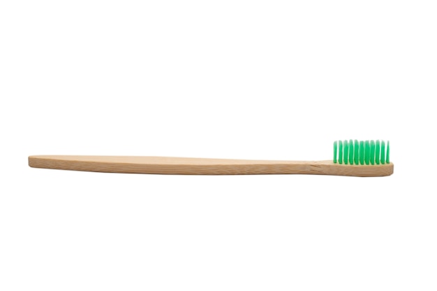 Escova de dentes de bambu isolada no branco.