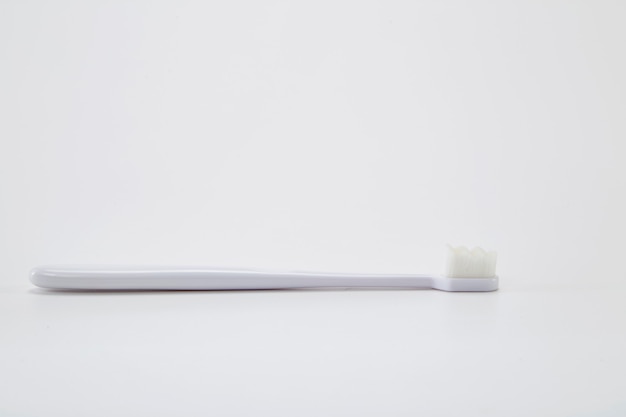 Escova de dentes de plástico branca com mesa de cerdas brancas