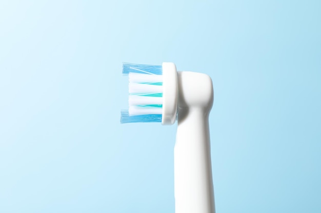 Foto escova de dentes elétrica em fundo azul claro close-up