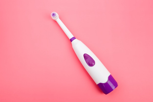 Escova de dentes elétrica moderna em um espaço rosa pastel