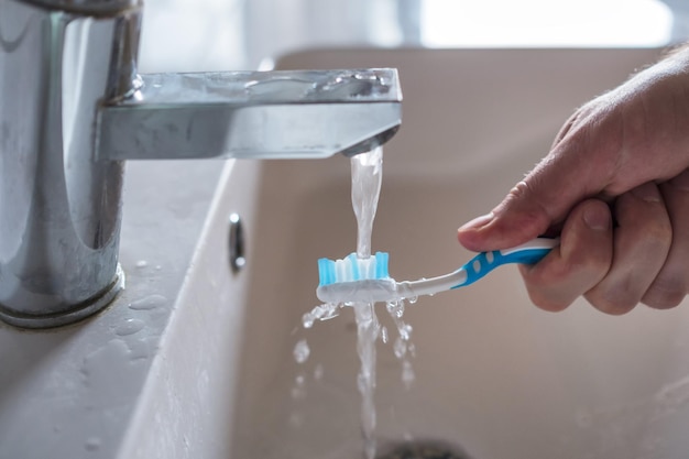 Escova de dentes lavando debaixo d'água pela manhã
