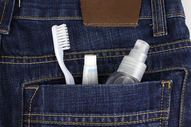 Escova de dentes, pasta e desodorizante bucal no bolso de trás da calça jeans. Conjunto de higiene bucal do turista.