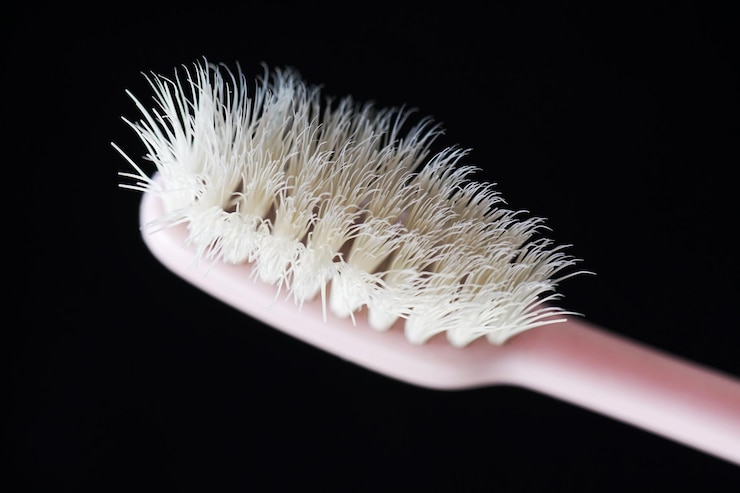 escova de dentes velha usada em fundo preto