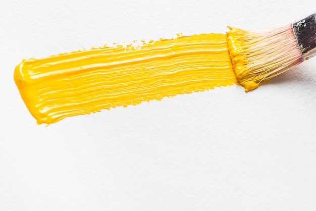 Escova e pincelada de tinta amarela