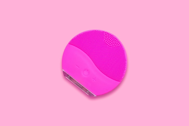 Escova facial de silicone no fundo rosa Gadget de beleza