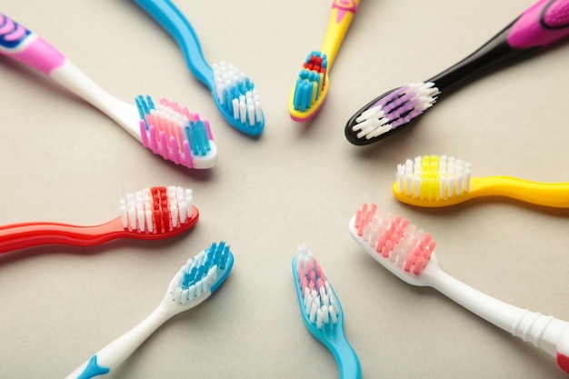 Escovas de dentes coloridas em fundo cinza vista superior