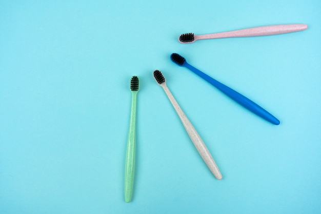 Escovas de dentes coloridas feitas de plástico reciclado em um fundo azul claro com espaço de cópia. Vista do topo