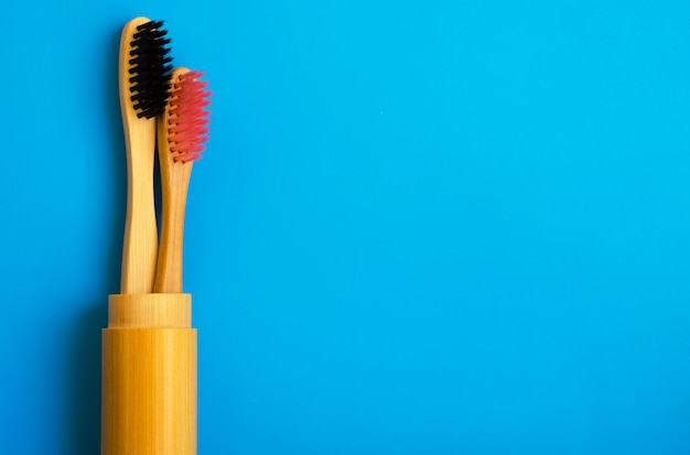 Escovas de dentes de bambu naturais de eco sobre fundo azul. zero resíduos plana leigos 14