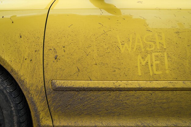 Escreva as palavras que o texto de inscrição me lava na superfície muito suja do carro. Lavagem de carro do conceito.