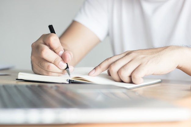 escrevendo, conceito de conhecimento e aprendizagem, mão de homem gravando informações em notebook