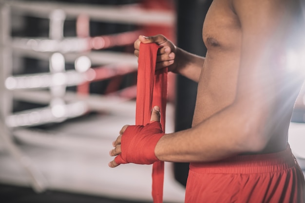 Escribiendo las manos. Kickboxer escribiendo un vendaje en su mano antes del entrenamiento