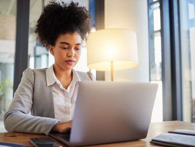 Escribir en una computadora portátil y una mujer de negocios seria leyendo correos electrónicos en el escritorio Profesional formal y trabajadora con enfoque y compromiso con su trabajo Empleado de oficina que trabaja en una computadora en un lugar de trabajo corporativo