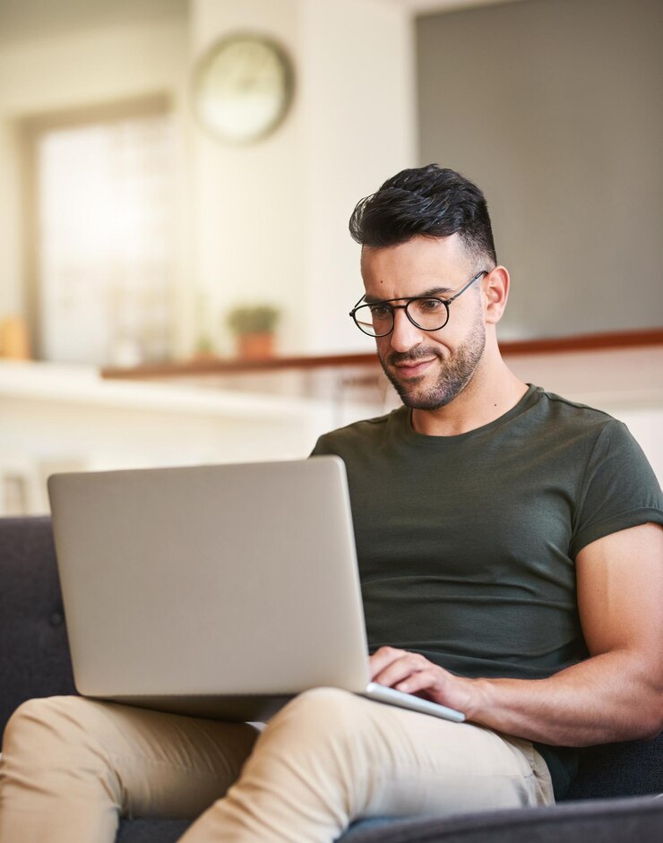 Foto escribir portátil y hombre con gafas en casa e investigación para proyectos de edición de video y redes sociales en el salón creación de contenido digital y ocupado en la sala de estar trabajo creativo y remoto en casa