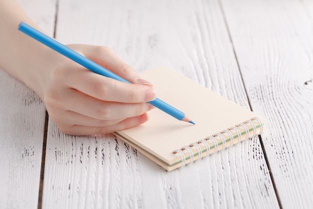 Escribir recuerdos nota, cerrar mano femenina con pluma