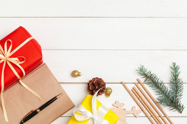 Escribir tarjetas de felicitación de navidad. Bloc de notas abierto con bolígrafo sobre mesa de madera decorada