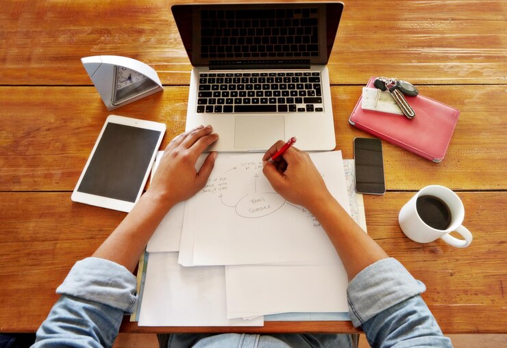 Foto escritor independiente de pov y planificación de horarios en un cuaderno con una computadora portátil para trabajo remoto mesa de casa y profesional independiente en una computadora que trabaja en productividad por la mañana con papeleo