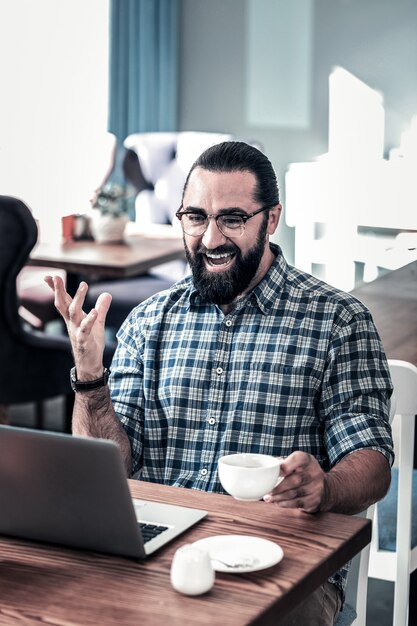 Escritor satisfeito. escritor freelancer barbudo sentindo-se verdadeiramente satisfeito e feliz lendo as críticas sobre seu trabalho