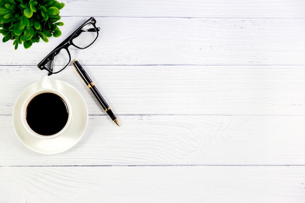 Escritorio blanco de madera con café.