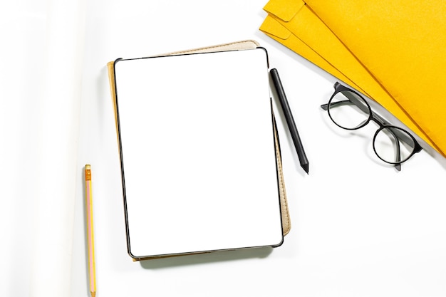 Escritorio blanco y vista de tableta Las manos del escritorio de trabajo de la vista superior están dibujando en una computadora de pantalla blanca en blanco