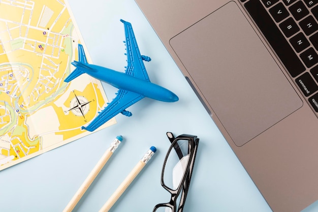 Escritorio con un café de mapa y un avión sobre un fondo azul Concepto de viaje