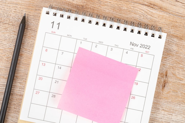 Escritorio de calendario de vista superior 2022 en el mes de noviembre, planificación de calendario y lápiz con nota adhesiva sobre fondo de madera. Concepto de reunión de cita de planificación empresarial