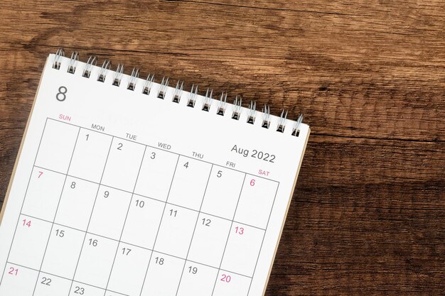 Escritorio de calendario de vista superior 2022, planificación de calendario en el mes de agosto sobre fondo de mesa de madera. Concepto de reunión de cita de planificación empresarial