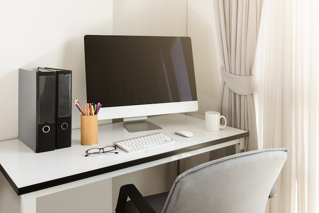 Foto escritorio de computadora en blanco con teclado, agenda y otros accesorios en mesa blanca