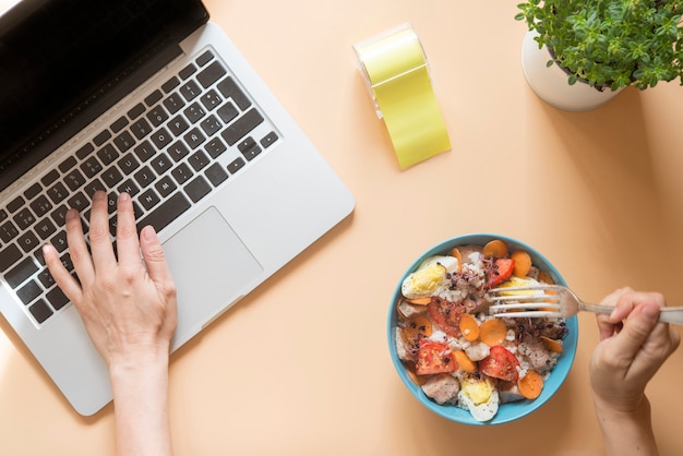 Foto escritorio con computadora con tazón de comida