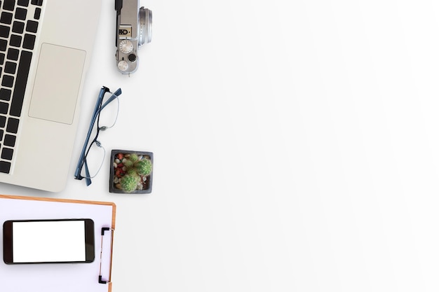 Foto escritório de mesa - computadores portáteis, telefones inteligentes, óculos, câmara antiga e cacto sobre fundo branco