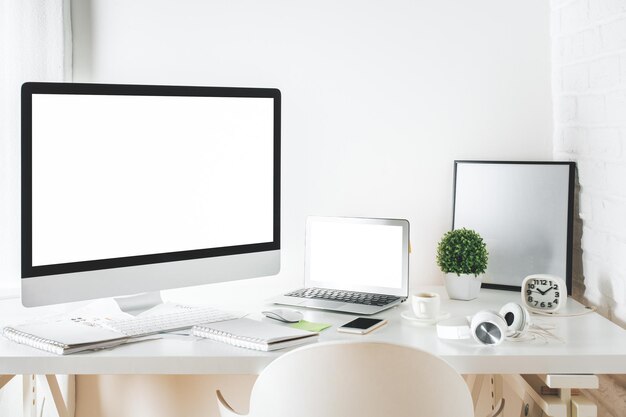 Escritorio de diseñador blanco con computadora y computadora portátil