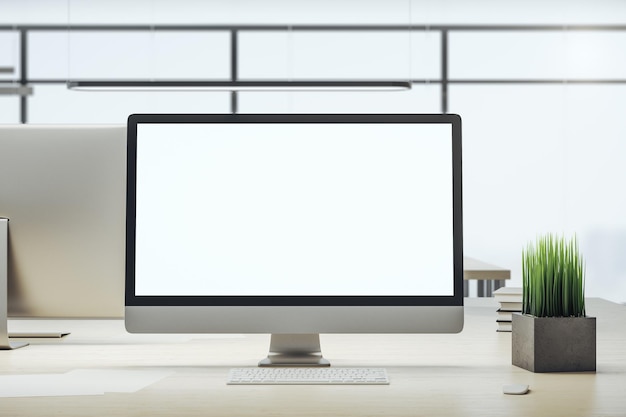 Escritorio de diseño con pantalla de computadora blanca y vacía