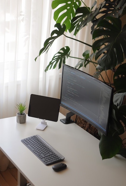 Escritório em casa aconchegante para desenvolvedor com tela curva e tablet. conforto no trabalho em casa