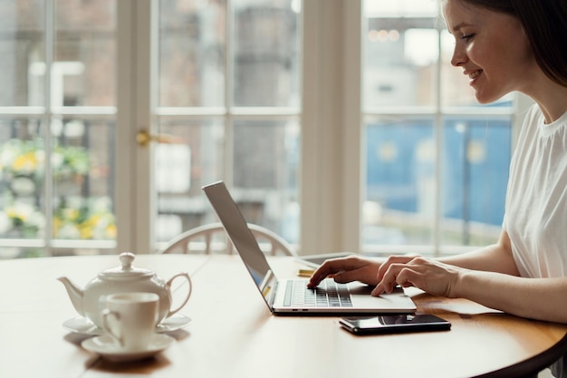 Escritório em casa online do estudante remotamente O designer está trabalhando em um laptop na sala de trabalho