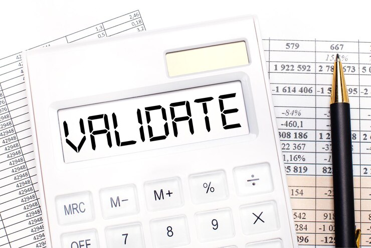 Foto en el escritorio hay informes de una calculadora blanca con el texto validar en el marcador y un bolígrafo concepto de negocio