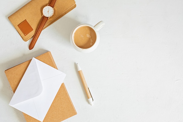 Escritorio minimalista con estilo con papelería de color orgánico, taza de café