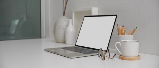 Escritorio moderno con laptop con pantalla blanca