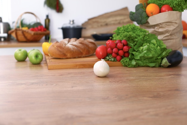 Foto escritorio con muchas verduras y frutas frescas en la cocina. concepto de cocina, vegetariano y compras.