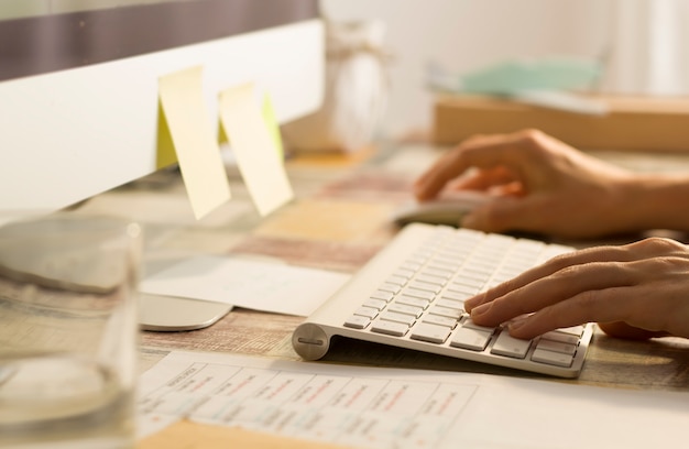 Escritorio. Mujer de negocios que trabaja en la oficina en el teclado en la computadora.