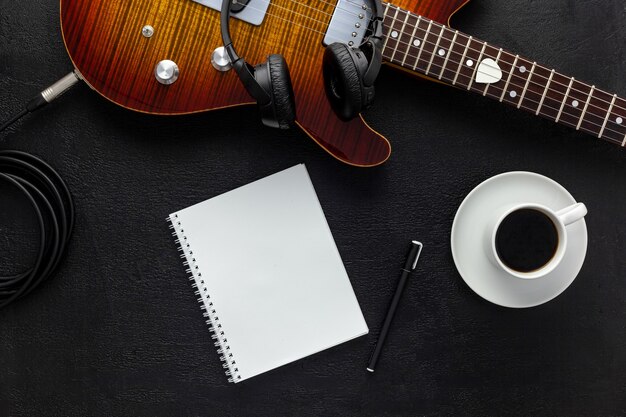 Foto escritorio de músico para trabajo de compositor con auriculares y guitarra