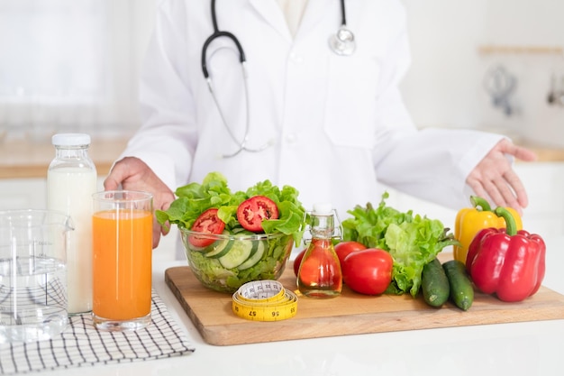 Escritorio de nutricionista con jugo de frutas saludables y cinta métrica Concepto de pérdida de peso y nutrición